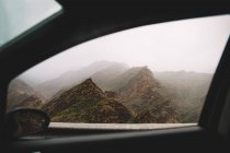 Neblige Berglandschaft vom Autofenster aus gesehen. — Stockfoto