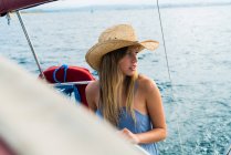 Портрет блондинки в солом'яному капелюсі дивиться в сторону на яхті в морі — стокове фото