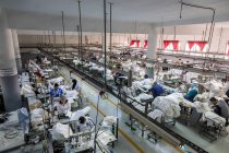 Tánger, MARRUECO- 18 de abril de 2016: Vista de alto ángulo a las máquinas de coser industriales y a los trabajadores - foto de stock