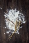 Борошно і пшеничні шипи на сільському дерев'яному столі — стокове фото