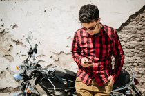 Uomo appoggiato su una bicicletta e utilizzando smartphone — Foto stock