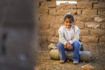 Арабських дівчинка сидить в руїнах і посміхається — стокове фото