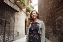 Cute young woman posing at street alley — Stock Photo