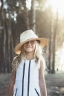Charmantes Mädchen posiert mit Hut im Sonnenlicht — Stockfoto
