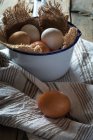 Eggs in metal bowl  on rural table — Stock Photo