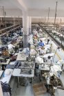Tánger, MARRUECO- 18 de abril de 2016: Vista de alto ángulo a las máquinas de coser industriales y maquinistas que trabajan - foto de stock