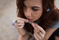 Girl with freckles rolling joint — Stock Photo
