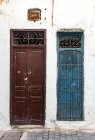 Exterior view of white facade with two shabby doors — Stock Photo