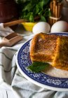 Vista da vicino del piatto decorato in ceramica con toast dolci e cucchiaio su asciugamano sopra la tavola con ingredienti — Foto stock