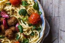 Изображение урожая спагетти с фрикадельками и помидорами черри на тарелке — стоковое фото