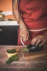 Mulher de colheita cortando berinjela na tábua de corte — Fotografia de Stock