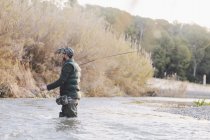 Vista lateral do homem que pesca no rio do país — Fotografia de Stock