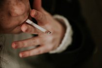 Обрезанное изображение девушки, курящей сигарету — стоковое фото