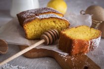 Still life of lemon cake slices on board with honey spoon — Stock Photo