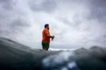 Чоловік стоїть на березі моря — стокове фото