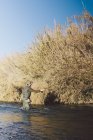 Pêcheur debout rivière par rive et pêche — Photo de stock