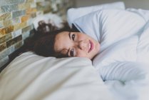 Girl lying in bed and looking at camera — Stock Photo