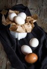 Организация куриных яиц и кружки на сельской ткани — стоковое фото