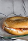 Cultivo delicioso bagel con salmón en el plato - foto de stock