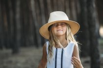 Усміхнений дитина в капелюсі в вечірньому лісі — стокове фото