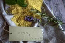 Natureza morta de ingredientes cuscuz derramados com sinal de papelão escrito à mão — Fotografia de Stock