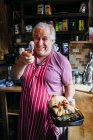 LONDRES, Reino Unido - 4 de mayo de 2017: Hombre alegre sosteniendo el plato y apuntando con pinzas a la cámara - foto de stock