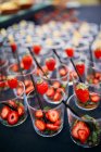 Row of empty glasses with strawberries slices — Stock Photo