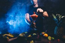 Uomo che prepara cocktail con fragola — Foto stock