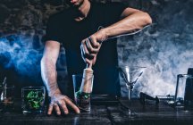 Man smashing ingridients for cocktail — Stock Photo