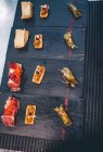 Conjunto de deliciosos bocadillos gourmet en platos - foto de stock