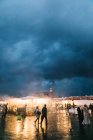Menschen laufen bei dichter Wolkendecke über den Marktplatz — Stockfoto