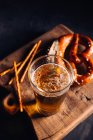 Glass of beer with some appetizer like pretzels — Stock Photo
