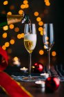 Garrafa derramando champanhe em copos — Fotografia de Stock