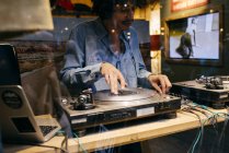 LONDON, Reino Unido - MAIO 4, 2017: Tiro através de vidro de homem de pé em estúdio jogando DJ console — Fotografia de Stock