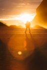 Silhouette de la personne marchant dans la lumière du coucher de soleil pittoresque — Photo de stock