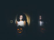 Mädchen hält Laterne und steht im hellen Fleck — Stockfoto