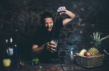 Мужчина наливает ингридиент в коктейльный бокал — стоковое фото