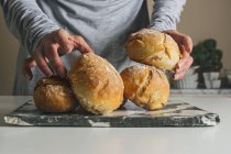 Руки женщины кладут хлеб на борт — стоковое фото