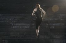 Спортивная девушка бежит вверх по лестнице — стоковое фото
