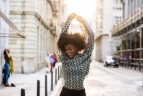 Woman posing with raised hands at stree — Stock Photo