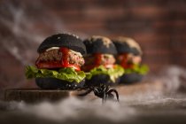 Fila de hamburguesas de halloween en tablero de madera - foto de stock