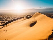 Persone che camminano su cresta di dune — Foto stock