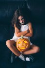 Ragazza maliziosa con zucca Halloween — Foto stock
