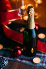 Bottle of champagne with candles — Stock Photo