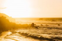 Vue panoramique des vagues lavant le littoral en plein soleil du matin . — Photo de stock