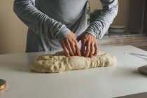 Woman massing bread: folding the dough into thirds, and sealing — Stock Photo