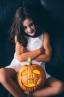 Chica maliciosa con la calabaza halloween - foto de stock