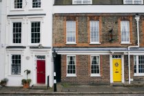 Внешний вид фасадов домов с яркими красочными дверями — стоковое фото