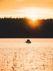 Bateau sur le lac au coucher du soleil — Photo de stock