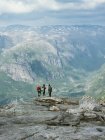 Туристы на скале над горной долиной — стоковое фото
